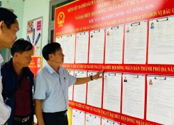 Lãnh đạo xã Nông Sơn kiểm tra việc niêm yết danh sách và tiểu sử tóm tắt người ứng cử tại khu vực bỏ phiếu. Ảnh: P.A