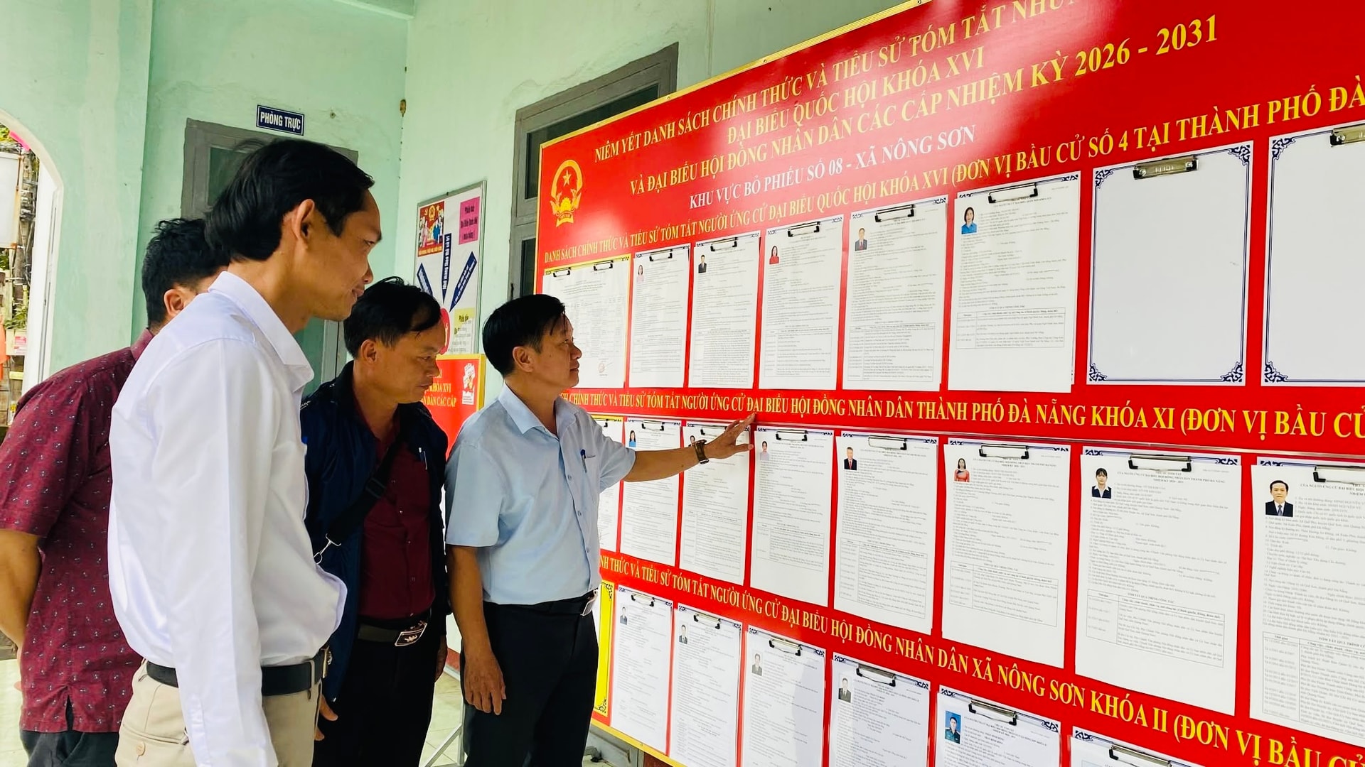 Lãnh đạo xã Nông Sơn kiểm tra việc niêm yết danh sách và tiểu sử tóm tắt người ứng cử tại khu vực bỏ phiếu. Ảnh: P.A